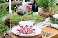 a cozy Christmas tea party tablescape with tree slice placemats, printed porcelain, evergreens, pinecones and candles