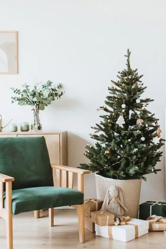 a modern Nordic Christmas tree in a basket, with lights and just several white Christmas ornaments is a lovely idea for your modern space