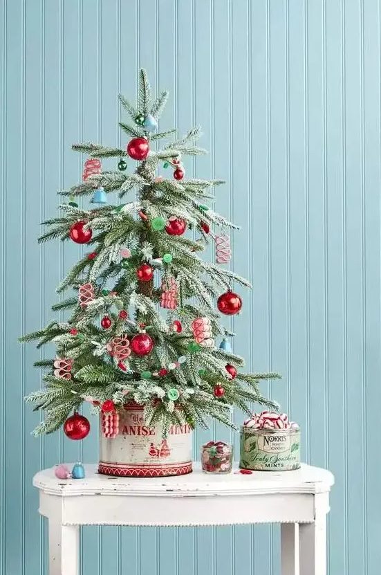 A retro inspired tabletop Christmas tree with blue bells, red and green ornaments, buttons is a lovely idea for your space