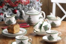 a simple Christmas tea party table with printed mugs and teaware on the whole and a Christmas cake served