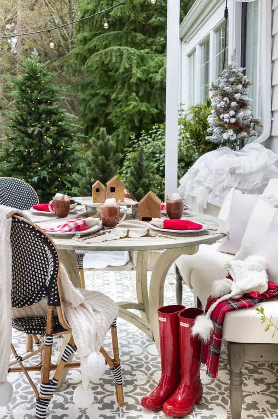 a simple and lovely Christmas tablescape with red and plaid napkins, wooden houses and hot chocolate welcomes