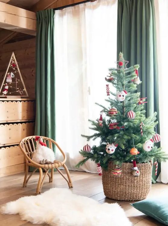 a small Christmas tree for a kids' room decorated with striped ornaments and funny pieces is a cool idea