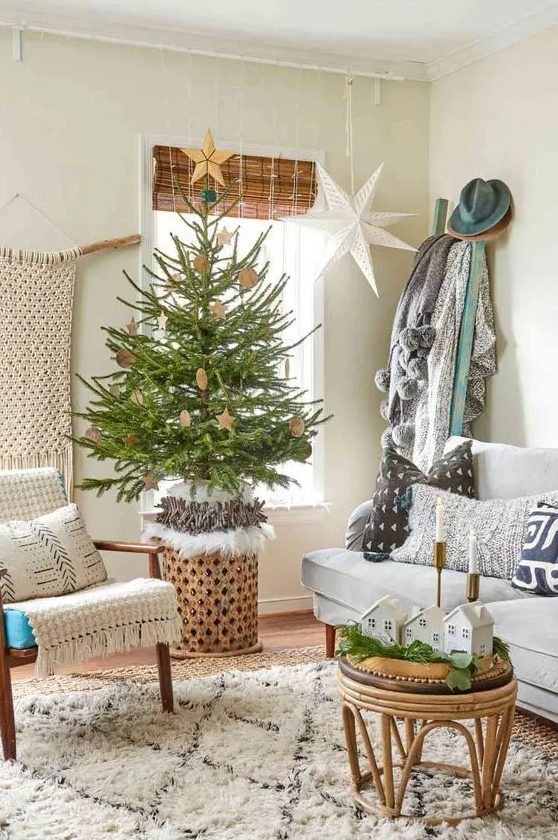 a small Christmas tree on a stand, with plywood ornaments and some lights brings a vintage feel to the space