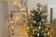 a small Christmas tree with lights, white baubles and stars, pinecones placed in a basket is a lovely decor idea