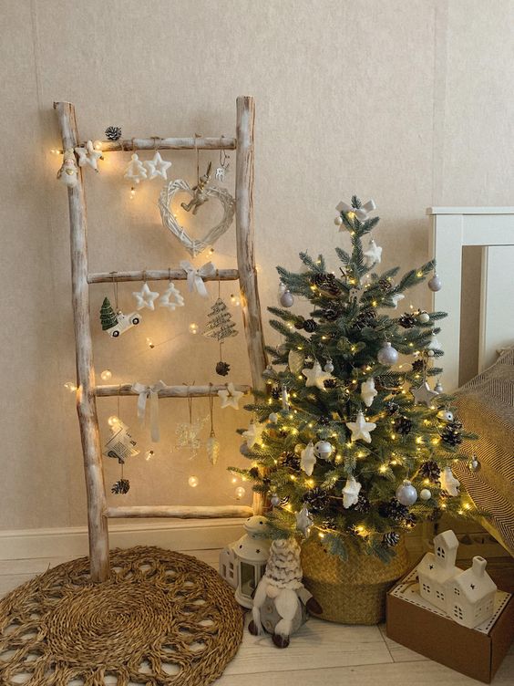 a small Christmas tree with lights, white baubles and stars, pinecones placed in a basket is a lovely decor idea