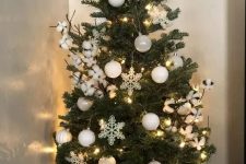 a small Christmas tree with white baubles, snowflakes and cotton and lights is amazing to style your space