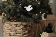 a small and pretty Christmas tree in a basket, with lights, white clay ornaments is a lovely decor idea for the holidays
