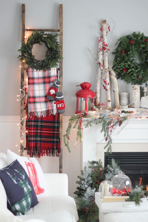 rustic mantel with branches, a red lantern and evergreens