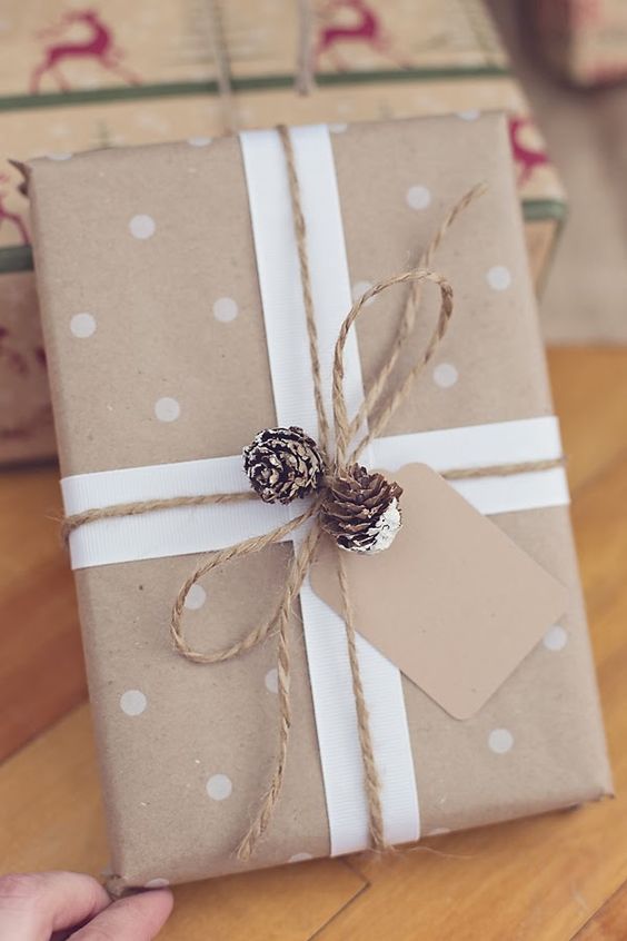 kraft paper, white paper, polka dots, twine and snowy pinecones