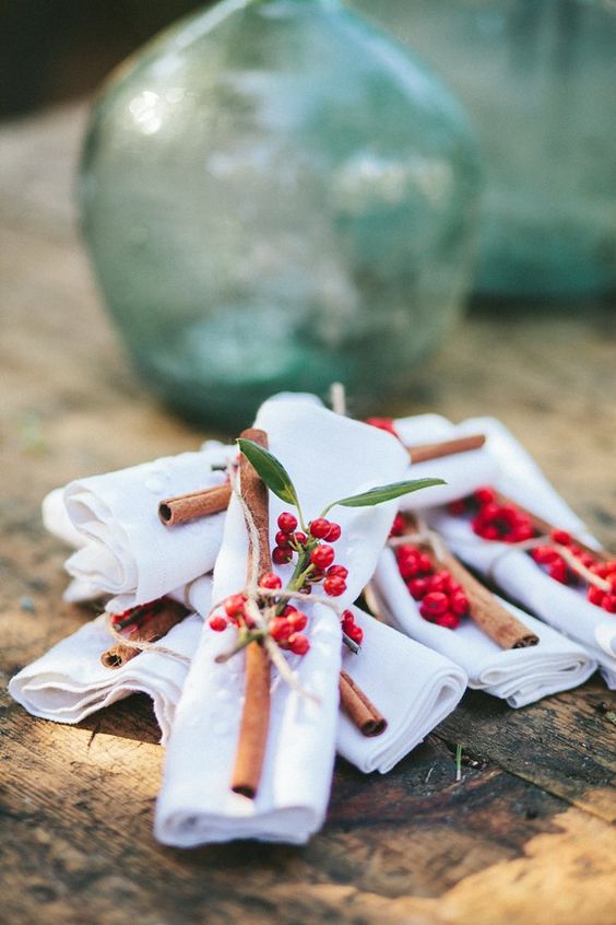 top the napkins with cinnamon sticks and holly berries