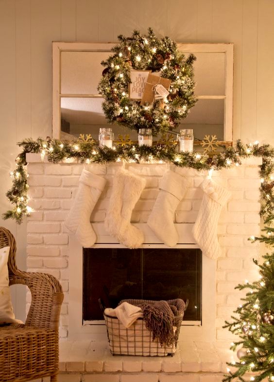 a garland and a wreath with lights, cozy white stockings