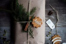 12 kraft paper, evergreens, cinnamon sticks and a cookie as a gift tag