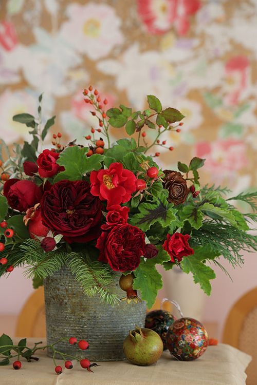 red and green Christmas bouquet in a galvanized bucket