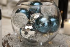13 a glass bowl with silver and blue ornaments inside