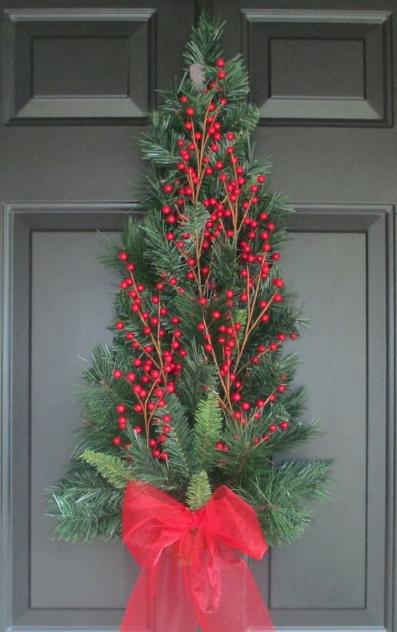 a small evergreen tree with holly berries and a bow instead of a usual wreath