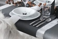 13 black and white table with black placemats and pinecones