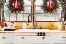 13 greenery wreaths with red bows make the kitchen cozier