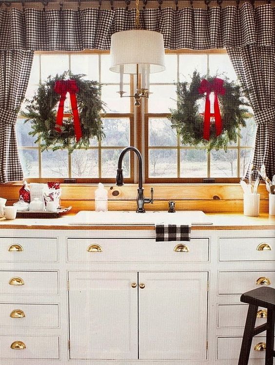 greenery wreaths with red bows make the kitchen cozier