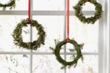 14 small boxwood wreaths with red ribbon