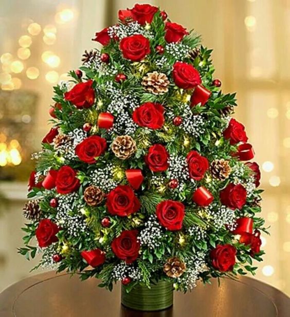 Colorful Christmas-tree shaped arrangement with pinecones and red ribbon