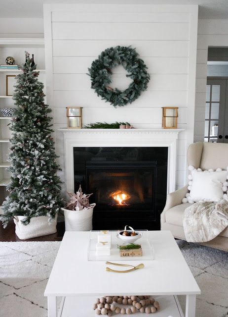 modern mantel decorated with a simple wreath and a laconic Christmas tree
