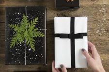 16 black and white wrapping paper, greenery, a clay star. cinnamon sticks and an elegant bow