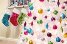 16 colorful ornaments seem to be floating in the air because of the pure white tree color