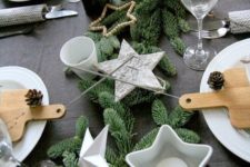 18 modern christmas table with a dark tablecloth, evergreens and white star candle holders