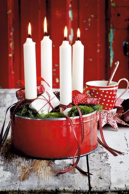 red bucket christmas bowl with moss, candles and red ribbon