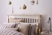 22 a light garland on the headboard and hanging ornaments over the bed
