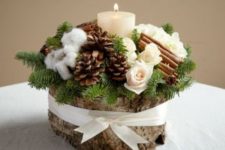 22 a wooden log with pinecones, evergreens, cinnamon sticks and a candle
