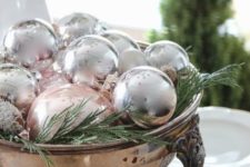 25 silver ornaments and fern displayed in an antique silver bowl