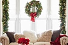 34 a thick evergreen garland and wreath with lights, red bows and pinecones