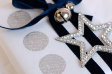 43 white paper, navy velvet ribbon, a silver star and jingle bells
