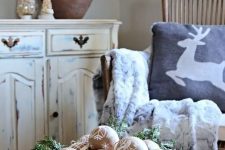 a Christmas arrangement of a wooden bowl with evergreens, cardboard ornaments with patterns is a cool idea