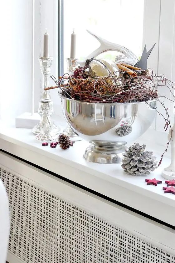 a Christmas centerpiece of a polished bowl with twigs, pinecones, cinnamon, antlers and lights is cool
