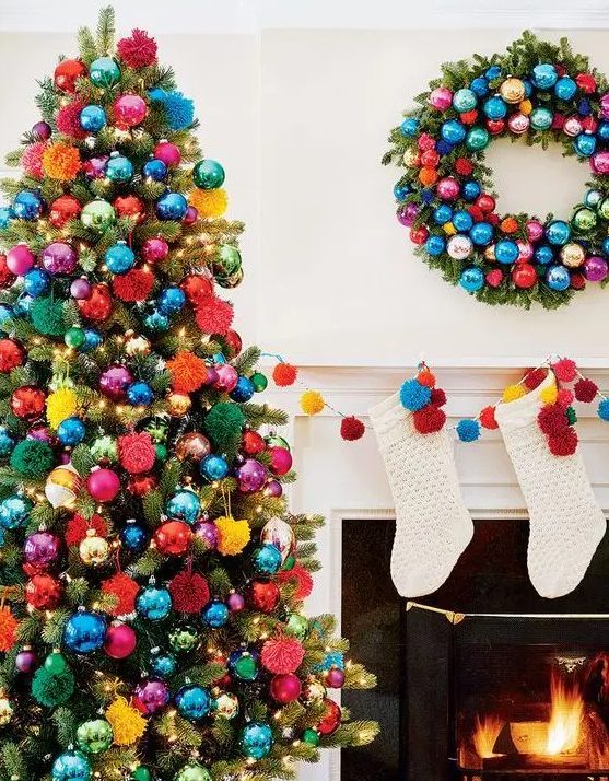 a Christmas tree decorated with super bold ornaments and pompoms plus lights is amazing