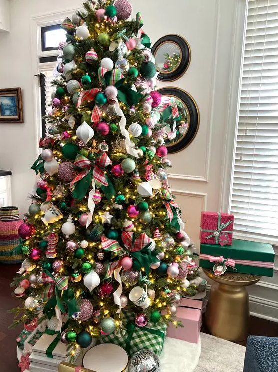 a tree styled with ribbon, pink and green ornaments and lights is a super chic and cool idea
