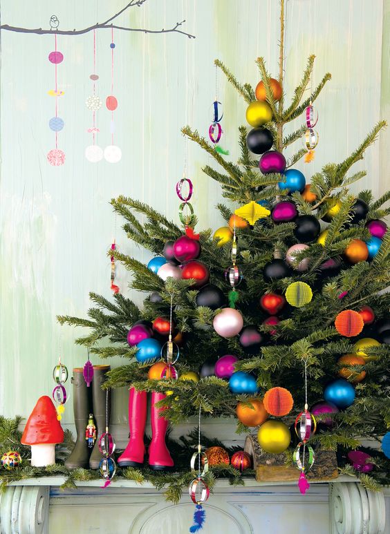 a bright Christmas tree decorated with colorful paper ornaments and baubles and black ones is amazing