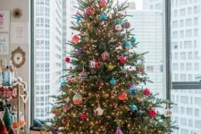 a bright Christmas tree with lights and colorful ornaments is a super catchy and cheerful decor idea