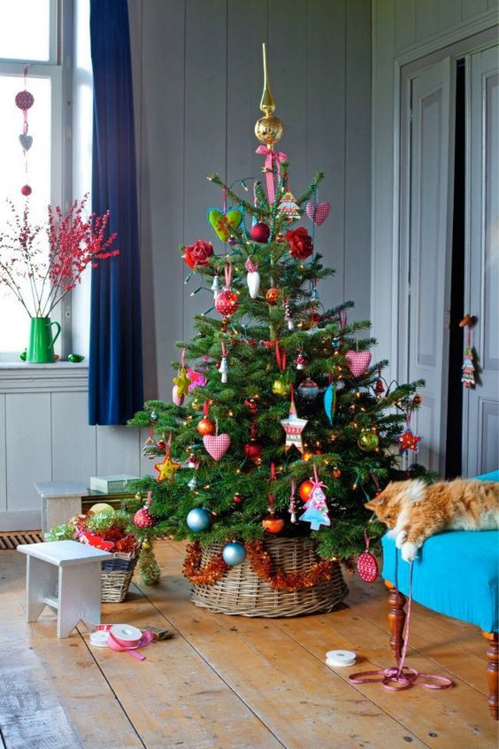 a bright Christmmas tree with colorful ornaments, bold blooms, hearts and mini trees is a cool and catchy idea