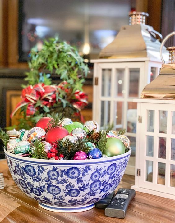a colorful Christmas centerpiece of a blue printed bowl, colroful vintage ornaments, evergreens is a cool decoration