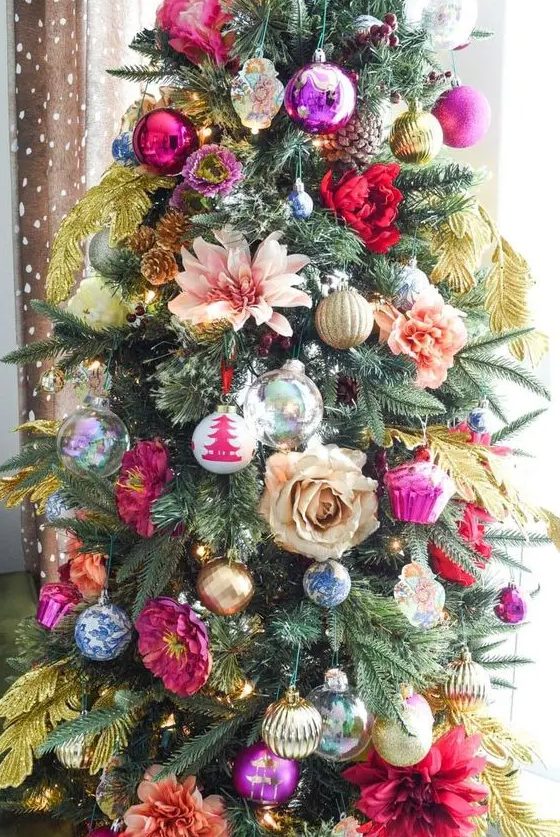 a colorful Christmas tree with bold bauble and cupcake ornaments, flowers and feathers is amazing