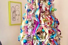 a flocked Christmas tree styled with pnk, green and blue ornaments and ribbons is a cool and bold idea to rock