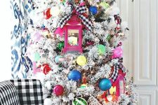 a flocked Christmas tree with colorful ornaments, pink lanterns and signs is a fun and cool decoration for the holidays