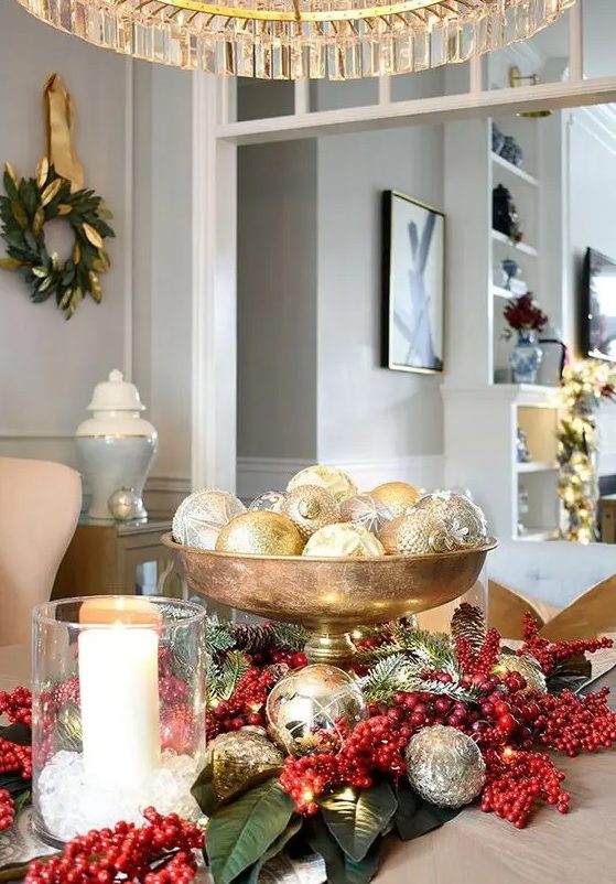 a glam Christmas centerpiece of a gold bowl with silver and gold ornaments and lights is a chic idea