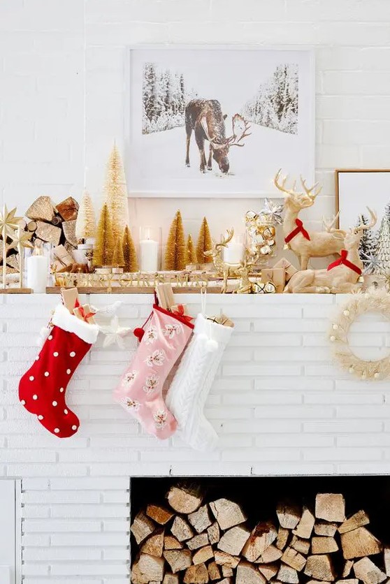 a glam woodland Christmas mantel with gold bottle cleaner trees, mismatching stockings, some deer figurines and bells in a jar