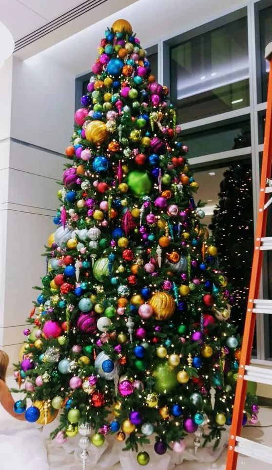 a jaw-dropping tall Christmas tree with colorful ornaments of various sizes and lights is a super cool and catchy idea