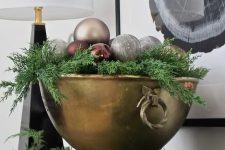 a large vintage bowl with evergreens, burgundy, grey and copper ornaments is a cool centerpiece