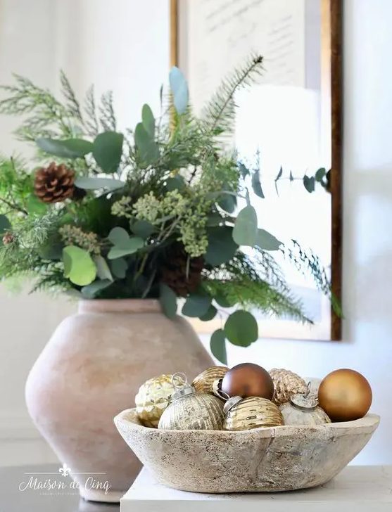 a lovely Christmas arrangement of a whitewashed bowl with gold and brown ornaments is a cool idea
